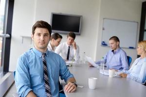 hombre de negocios en una reunión en la oficina con colegas en segundo plano foto