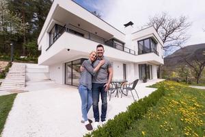 couple hugging in front of  new luxury home photo