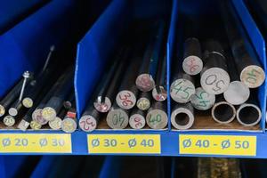 pipes, metal pieces and various metal parts for a CNC machine standing on a shelf photo