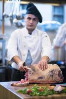 chef cutting big piece of beef photo