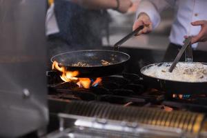 chef preparing food, frying in wok pan photo