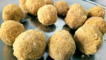 Mouth watering sweet - Besan laddoo made by roasted gram flour, ghee, dry fruits and sugar, served in a plate photo