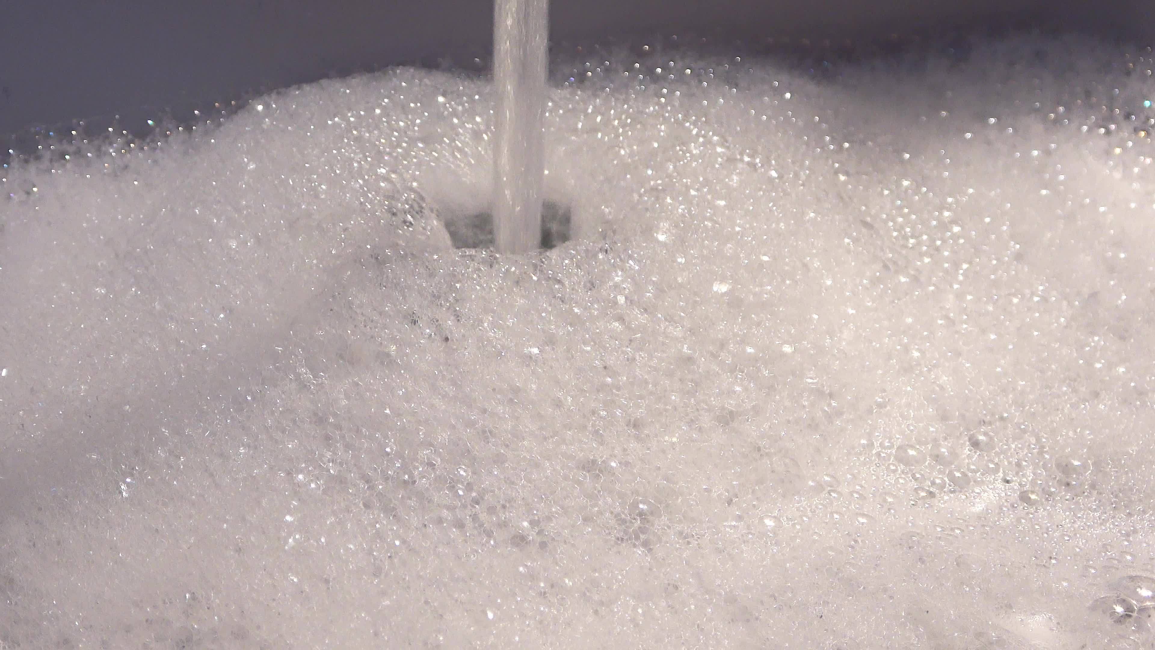Foam and soap bubbles from water in a sink with water running from a water tap. 12086005 Stock