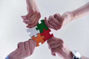 Group of business people assembling jigsaw puzzle photo