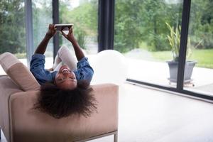 african american woman at home with digital tablet photo