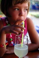 linda niñita disfrutando de una bebida fría foto