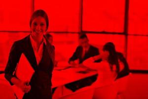 business woman with her staff in background at office photo