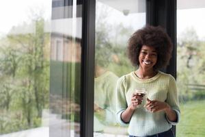 African American woman drinking coffee looking out the window photo