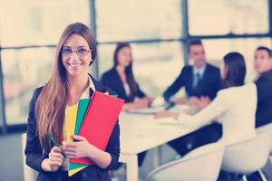 business woman with her staff in background at office photo