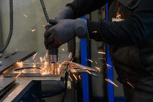 una mujer que trabaja en la industria moderna de producción y procesamiento de metales suelda el producto y lo prepara para una máquina cnc foto