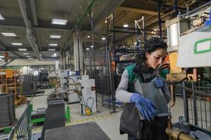 Turkey, 2022 - a woman working in a modern metal factory assembles parts for a new machine