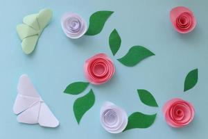 Origami paper background with butterflies, flowers and leaves. Origami composition. Paper craft photo