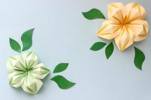 banner con flores de origami amarillas y verdes y hojas de papel con lugar para su diseño. fondo de papel foto