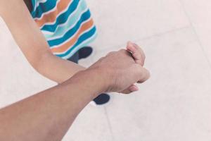 Close up of parent and child holding hands. photo