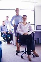 business woman with her staff in background at office photo