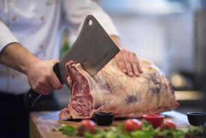 chef cutting big piece of beef photo