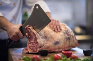 chef cortando un gran trozo de carne foto