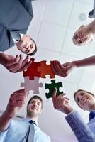 Group of business people assembling jigsaw puzzle photo