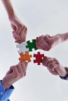 Group of business people assembling jigsaw puzzle photo