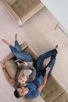 pareja joven en la sala de estar con vista superior de la tableta foto