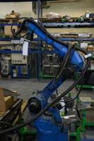 El brazo mecánico del robot de soldadura automática está trabajando en la moderna fábrica de piezas de automóviles. foto