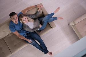 youg couple in living room with tablet top view photo