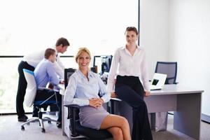 business woman with her staff in background at office photo