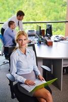 business woman with her staff in background at office photo