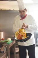 chef in hotel kitchen prepare food with fire photo