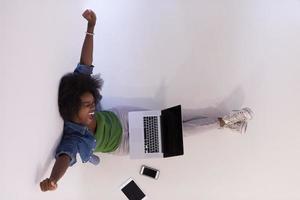 african american woman sitting on floor with laptop top view photo