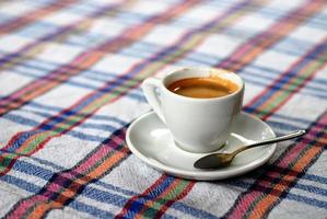 Cup of coffee on a colorful tablecloth photo