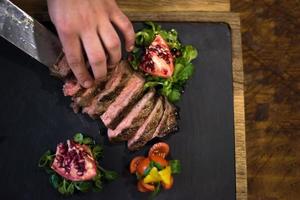 top view of Chef hands serving beef steak photo