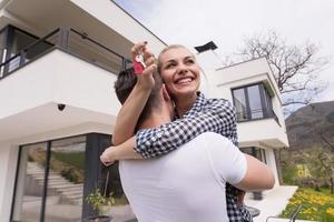 couple hugging in front of  new luxury home photo