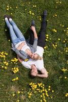 man and woman lying on the grass photo