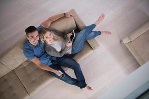 youg couple in living room with tablet top view photo