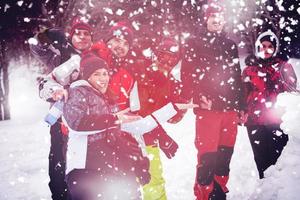 group portait of young people posing with snowman photo