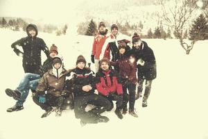 retrato de grupo de jóvenes posando con muñeco de nieve foto