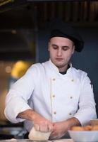 young chef preparing dough for pizza photo