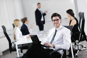 Portrait of a handsome young business man with colleagues in background photo