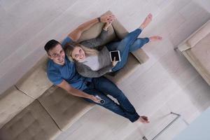 youg couple in living room with tablet top view photo