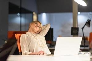 woman working on laptop in night startup office photo