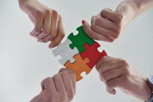 Group of business people assembling jigsaw puzzle photo