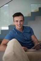 young man using a tablet at home photo