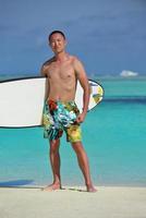 Man with surf board on beach photo