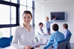 business woman with her staff in background at office photo