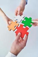 Group of business people assembling jigsaw puzzle photo