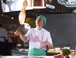 chef throwing up pizza dough photo