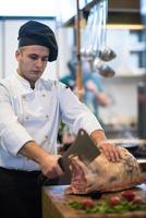 chef cortando un gran trozo de carne foto