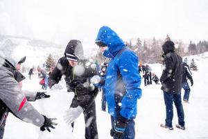 group of young people making a snowman photo