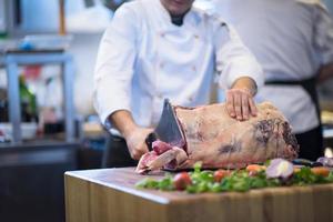 chef cortando un gran trozo de carne foto